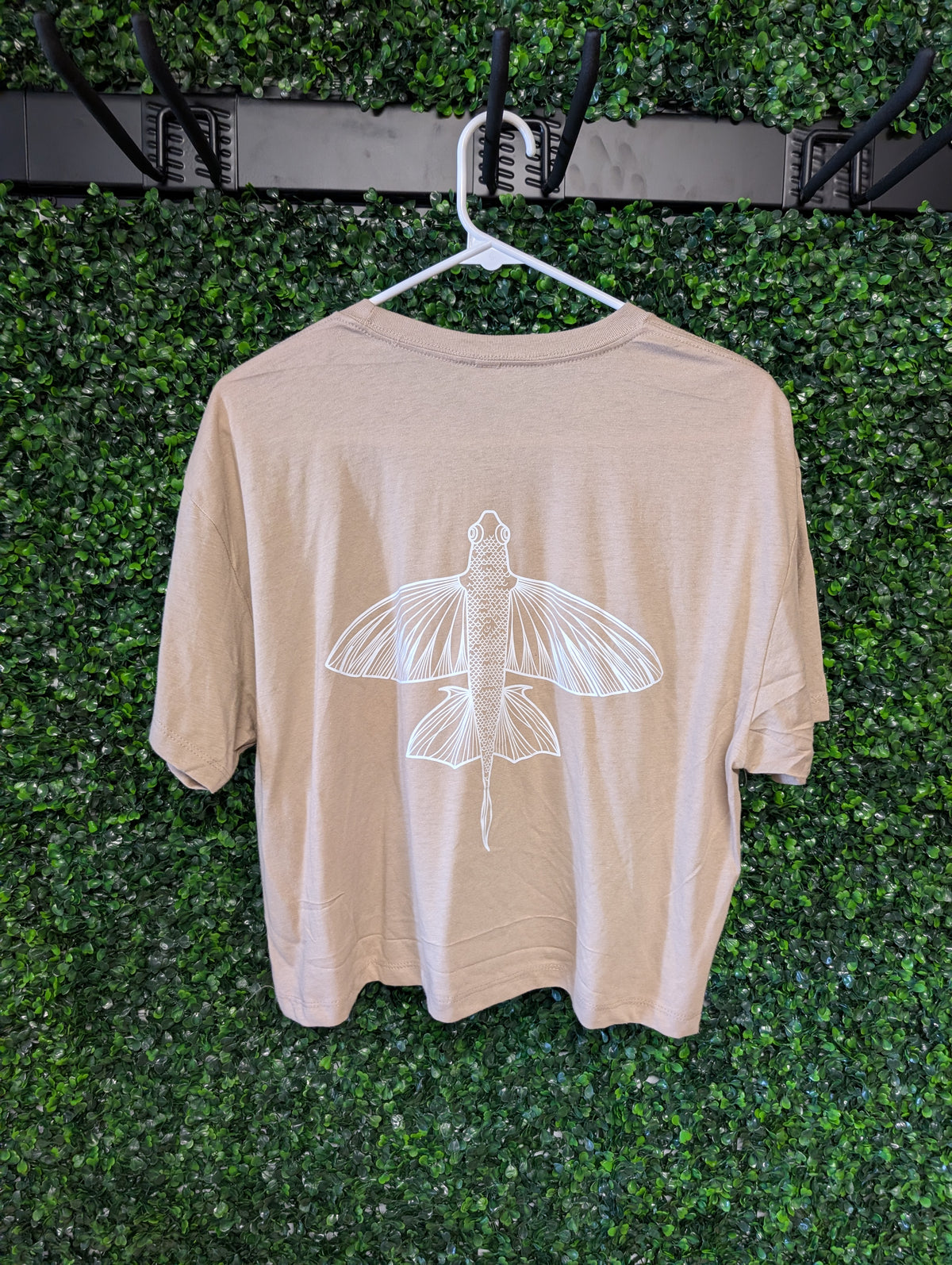 Front of tan Puakea crop top with white Puakea Designs chest logo.